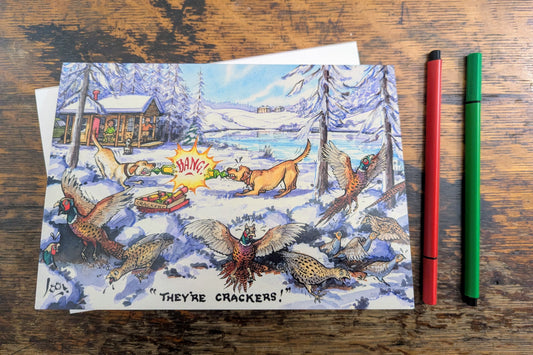 Colorful card with a hunting scene featuring a dog and birds on a wooden surface with two pens.